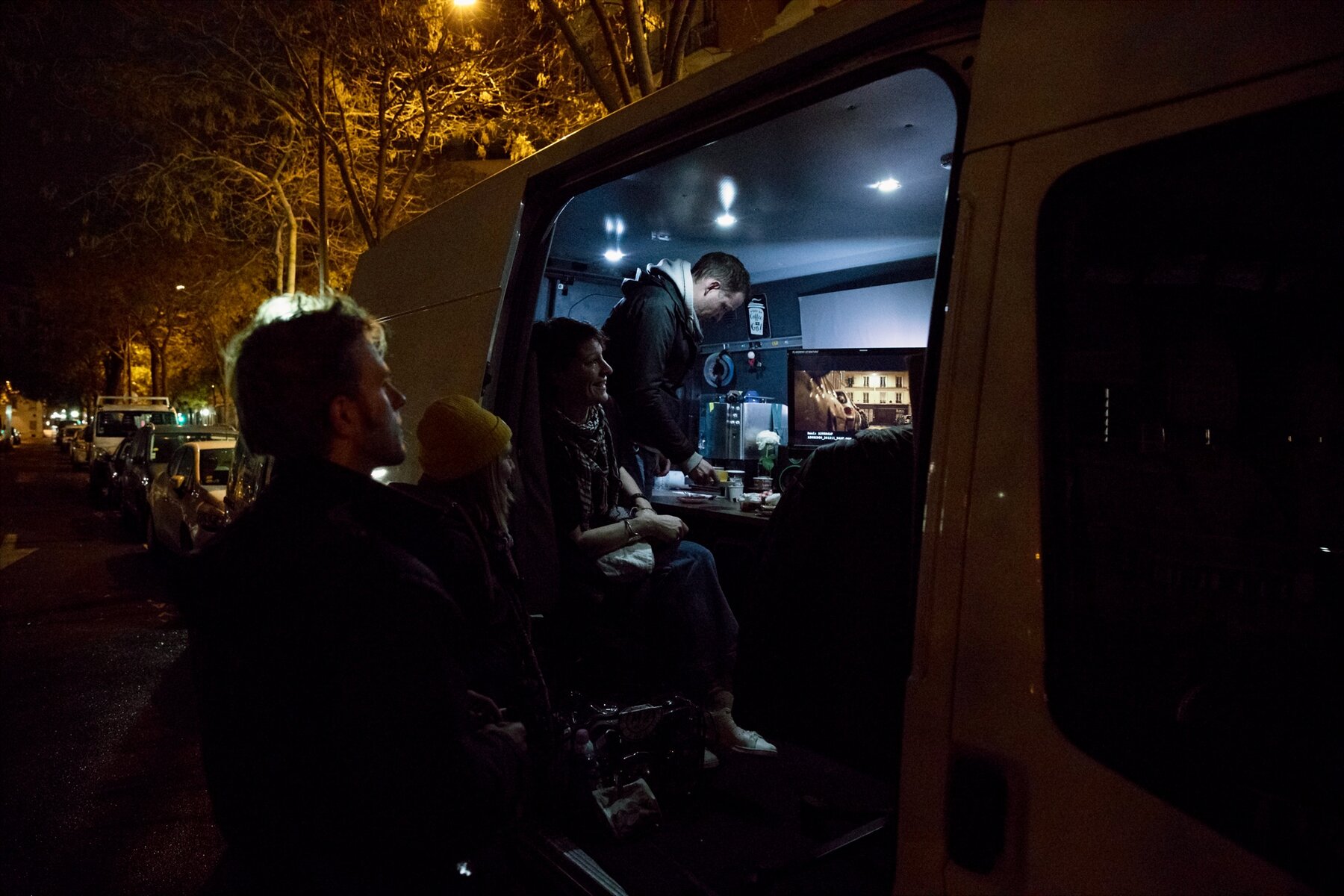 Le van ouvert la nuit, l'équipe autour du moniteur
